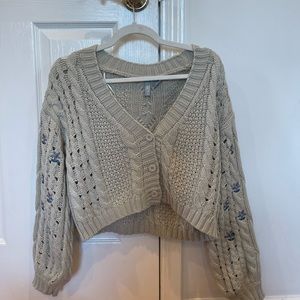 gray/green-ish sweater with flowers on the sleeves